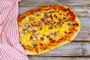 Homemade pizza with tomatoes, mozzarella. Top view on wooden table with copy space