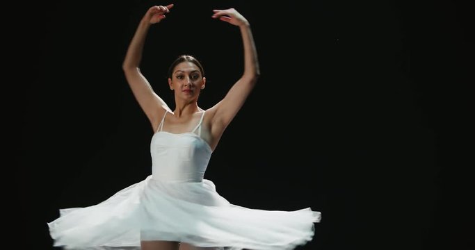 4K video footage closeup of a beautiful female ballet dancer on black background, slow motion