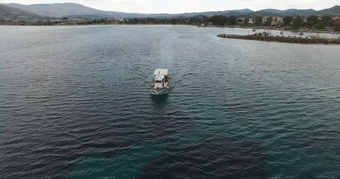 A fishing boat is leaving the shore during the nightfall