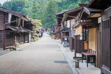 Fototapeta na wymiar Narai-juku, Japan - September 4, 2017: Picturesque view of old Japanese town with traditional wooden architecture. Narai-juku post town in Kiso Valley, Japan
