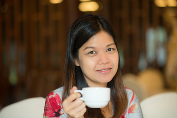 Asian middle age woman drinking coffee in the coffee shop