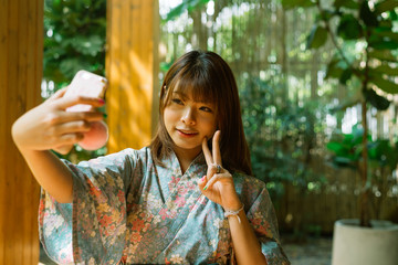 Lifestyle series: Asian woman in yukata using smartphone taking selfie