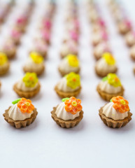 A lot of artificial cupcakes on white surface with shallow depth of field background.