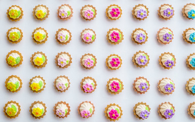 A lot of artificial cupcakes on white surface with shallow depth of field background.
