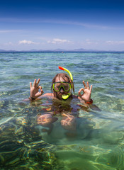 Young man snorkeling in clear shallow tropical sea