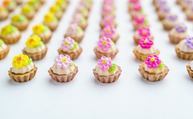 A lot of artificial cupcakes on white surface with shallow depth of field background.