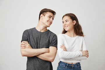 Lovely couple looking at each other with crossed hands while smiling. Girlfriend decided with her cute boyfriend to buy puppy. Maybe it will make their raletionship stronger. How should they call it.