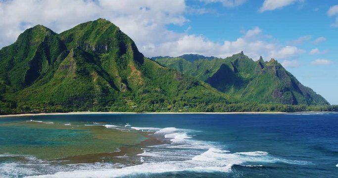 Cinematic aerial view of dramatic mountains and beautiful ocean on North Shore of Kauai