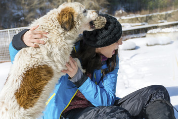 Woman playing with dog on the snow.Love dogs