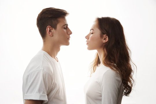 Couple standing face to face with their eyes closed. Boyfriend and girlfriend imagine their future together. There is only one mismatch. She sees cat and he is more like a dog person.
