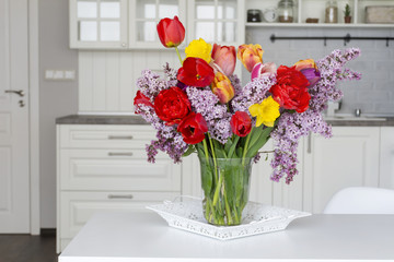 bouquet of fresh tulips and  lilac  on a table in the kitchen