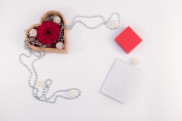wooden box heart shape with beads and flower gerberas and red box and other items on a white background