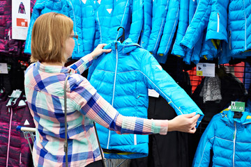 Woman chooses winter jacket in store