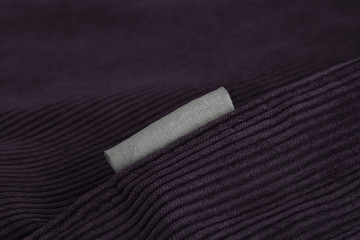 Velvet fabric with a seam along the diagonal and a gray label, close-up.