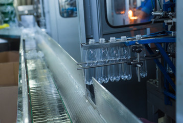 Naklejka premium Plastic water bottles on conveyor and water bottling machine industry