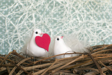 Two little white birds in love in the nest with red heart. Valentine's Day.  Selective focus