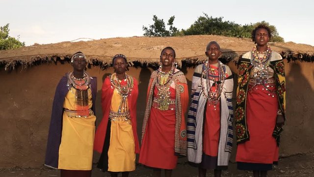 panning shot of five maasai women singing in a village near mara, kenya