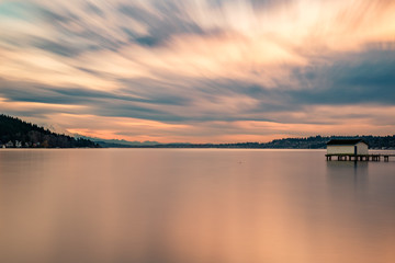 A long exposure of the sunset lighting up the cloudy sky over Lake Washington