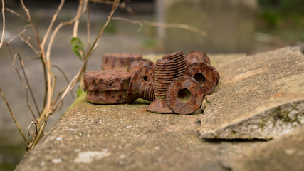 Some rusty screws on a slab of concrete