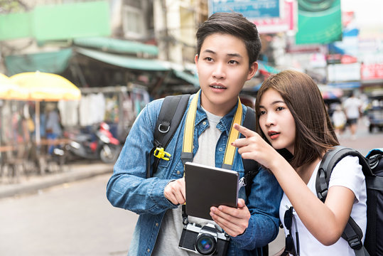 Asian couple tourist using tablet to find location while traveling in Thailand