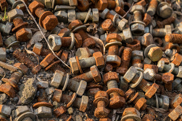 Rusty bolts and nuts on the floor in the sunlight