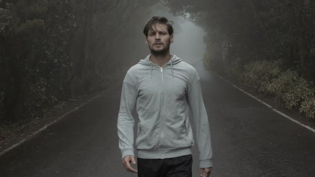 Young, fit jogger running in a tropical forest - slow motion