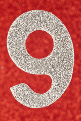 Number nine silver color over a red background. Anniversary.