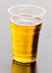 Fresh beer in a plastic glass on the table