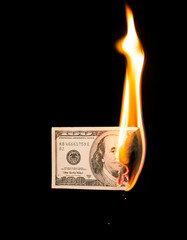 a hundred dollars burn in a fire on a black background