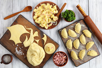 raw pierogi on wooden cutting board
