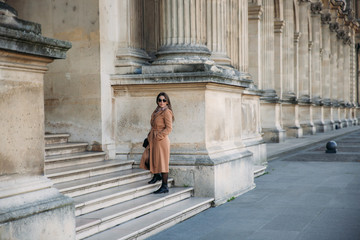 Stylish girl in coat posing for photographer