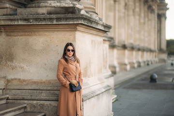 Stylish girl in coat posing for photographer