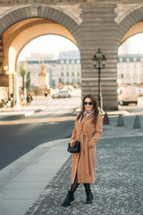 Fototapeta premium Stylowa dziewczyna w płaszczu pozowanie dla fotografa