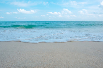 Fototapeta na wymiar Waves on tropical white beach with blue sky background