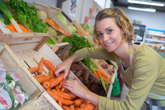 smiling female seller in vegetables market