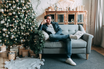 Obraz premium young handsome guy in the studio with a New Year theme, gay