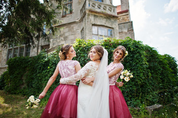 Fototapeta premium Happy bride and outgoing bridesmaids having fun on the wedding day next to a castle.