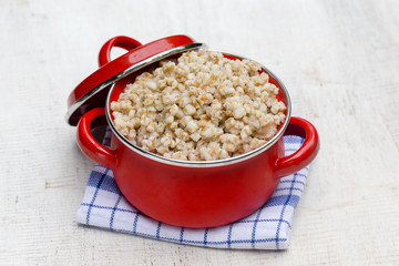 Red pan with wheat porridge - traditional meal in Ukraine, Belarus and Russia