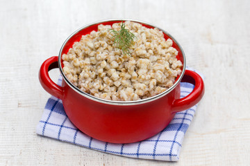 Red pan with wheat porridge - traditional meal in Ukraine, Belarus and Russia