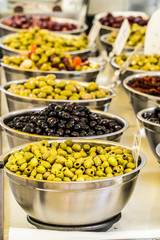 Different cured table olives in the bowls.