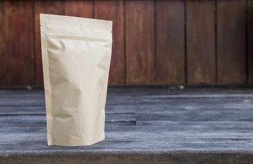 Brown paper bag with space on wood background, tea bag packaging 
