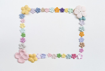 Color paper flower arrange in frame shape on white paper texture background, valentine card concept, greeting card background