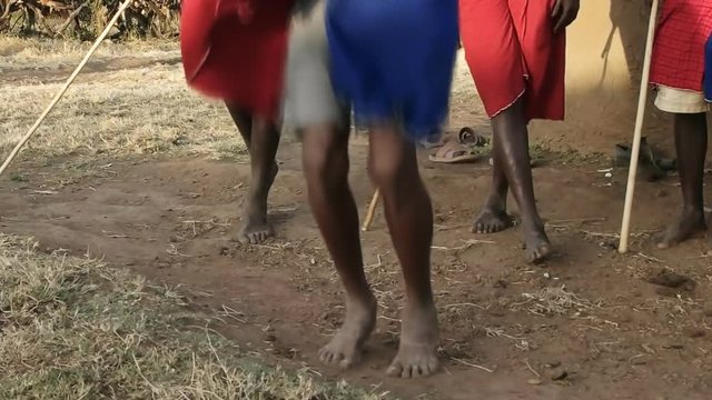 60fps close up shot of the feet and legs of maasai warriors jumping and dancing at a village near maasai mara, kenya- originally recorded at 120fps