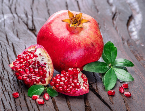 Ripe pomegranate fruits on the wooden background.