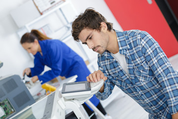 young technician trying to repair printer