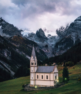 Church with bell tower in Trafoi village against Stelvio mountains in dusk, Alps in Italy