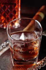 Glass of  whiskey and cigar on old wooden table.