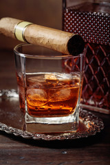 Glass of  whiskey and cigar on old wooden table.