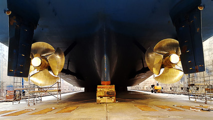 black ship hull and golden propeller at drydock