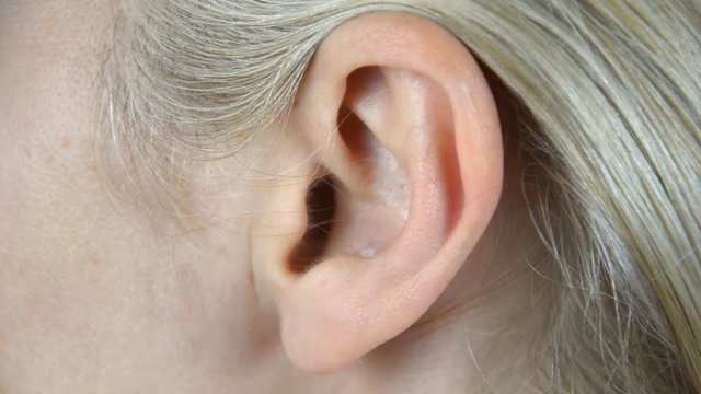 Close-up footage of woman's ear. No movement.